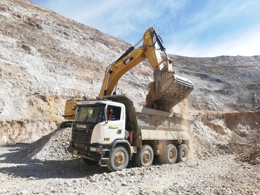 heavy-construction-equipment-in-quarry-29506742 Excavator loading dump truck in a quarry. Industrial mining equipment scene.